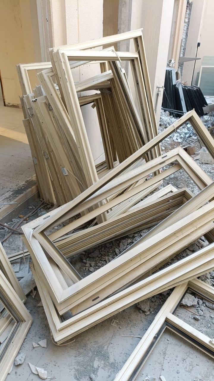 Stack of removed aluminium window frames at a renovation site