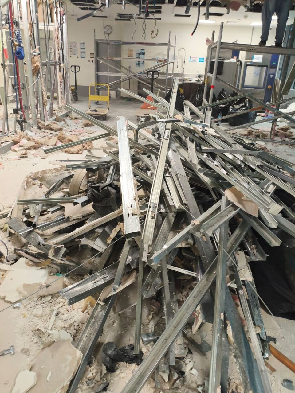 Mixed demolition debris with metal studs and plasterboard on an interior site